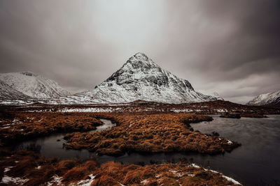 Mountains in scotland in rannoch moor with dark cloudy sky and lake