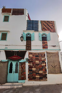 Handmade moroccan carpets hanging on the building of a carpet store in asilah