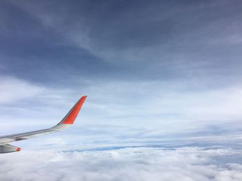 Airplane flying over cloudscape against sky