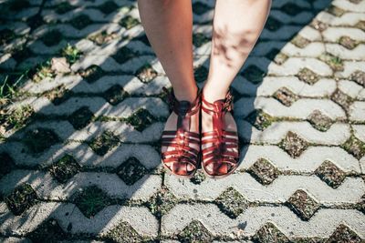 Low section of woman standing on footpath