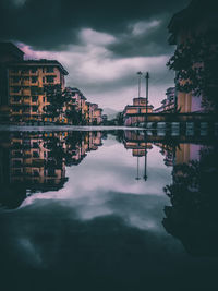 Reflection of buildings in lake against sky