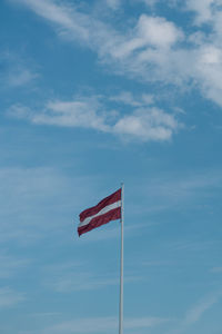 Low angle view of latvian flag against sky