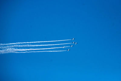 Low angle view of airplane flying against blue sky