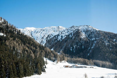 Scenic view of snowcapped mountains against clear sky