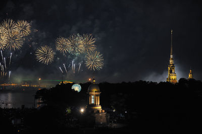 Firework display over river in city at night