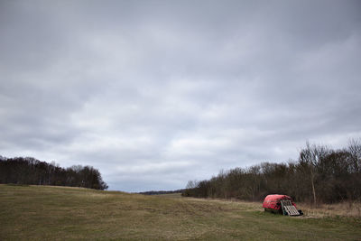 Scenic view of grassy field against cloudy sky