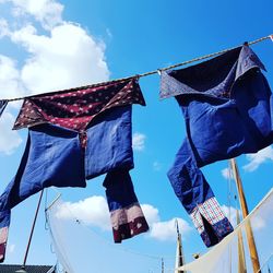 Low angle view of flags hanging against sky