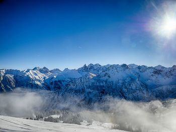 Scenic view of snowcapped mountains against clear blue sky