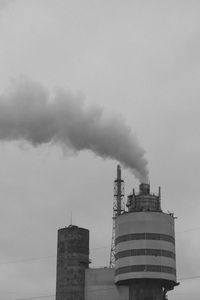 Low angle view of smoke emitting from chimney against sky