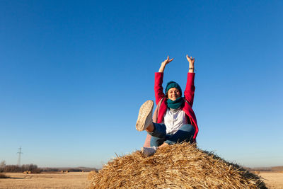 Full length of smiling man on field against clear blue sky