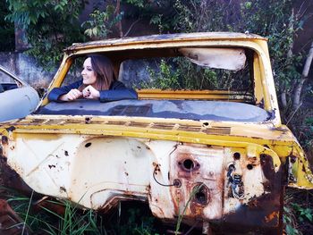 Portrait of woman in abandoned car
