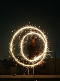 Man spinning sparkler at night
