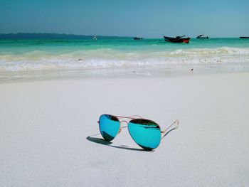 Ray ban sunglasses on beach against sky in havelock island