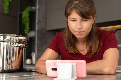 Young woman using mobile phone at home