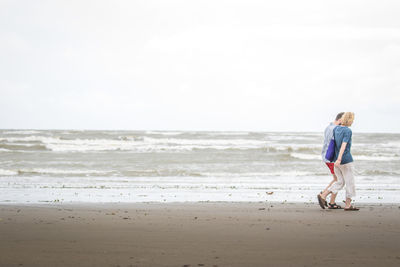 Full length of man standing on beach against sky