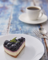 Coffee cup and cake on table
