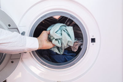 Close up of a washing machine with clothes isolated on white background