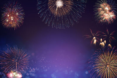Low angle view of firework display at night