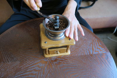 High angle view of person grinding coffee on table