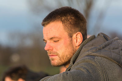 Close-up of thoughtful man wearing hooded jacket