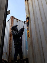 Low angle view of man working on building