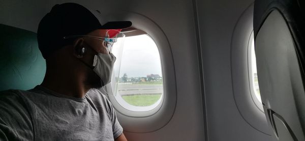 Portrait of man seen through airplane window