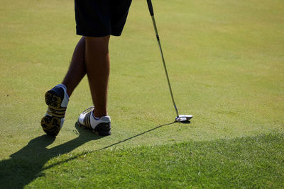 Low section of person standing on golf course