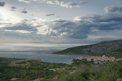 Scenic view of sea by buildings against sky