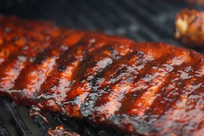 Cropped image of grilled meat on metal grate
