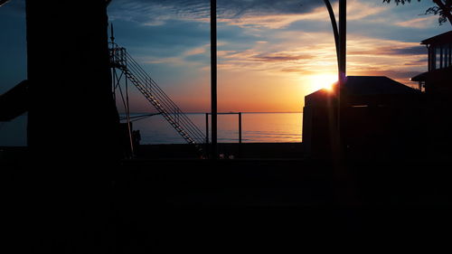 Silhouette sailboat on sea against sky during sunset