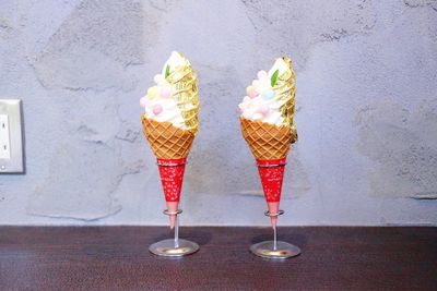Ice cream cone on table against wall