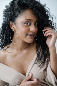 Portrait of a beautiful dark skin woman with long curly hair smiling