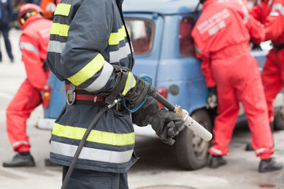 Midsection of firefighter standing on road