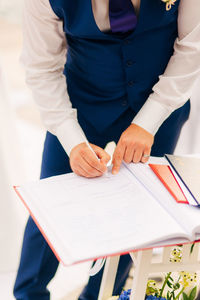 High angle view of man writing in book