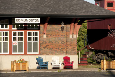 Empty bench by building in city