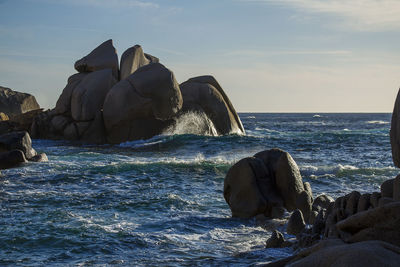 Rock formation in sea against sky