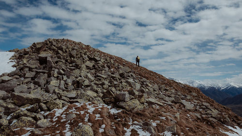 Low angle view of person on rock against sky