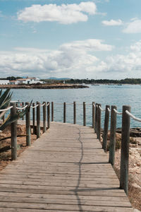 Wooden pier over sea against sky