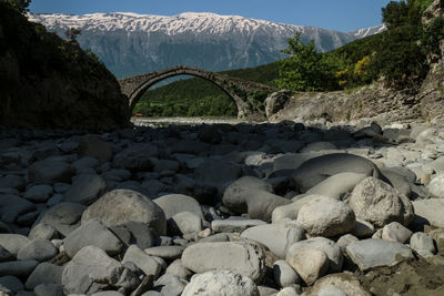 Arch bridge over river against mountains