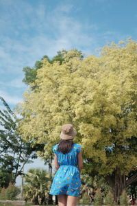 Rear view of woman standing on field