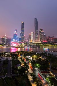 Illuminated buildings in city against sky at night