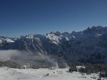 Scenic view of snowcapped mountains against clear blue sky