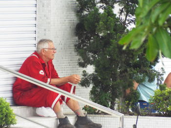 Full length of man with red umbrella