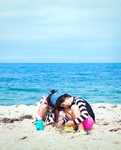 Young woman at beach against sky