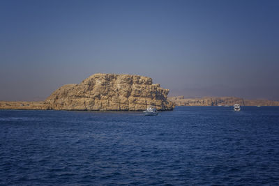 Scenic view of sea against clear blue sky