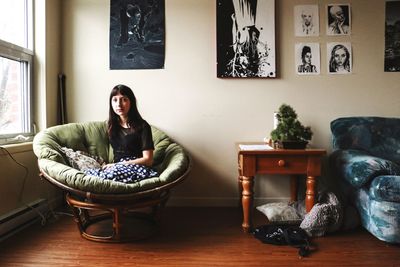 Portrait of young woman sitting on sofa at home