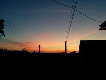 Silhouette of electricity pylon at dusk