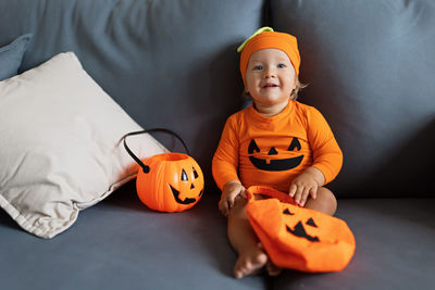 Portrait of cute baby sitting on sofa at home