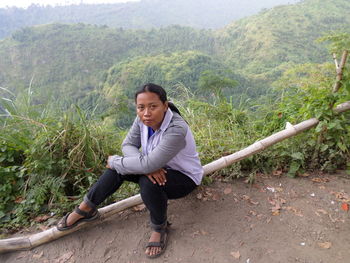 Portrait of young man sitting on mountain