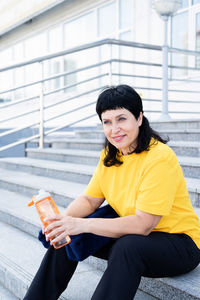 Portrait of a smiling young woman sitting outdoors